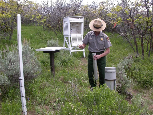 NPS employee at climate monitoring station NPS employee at climate monitoring station