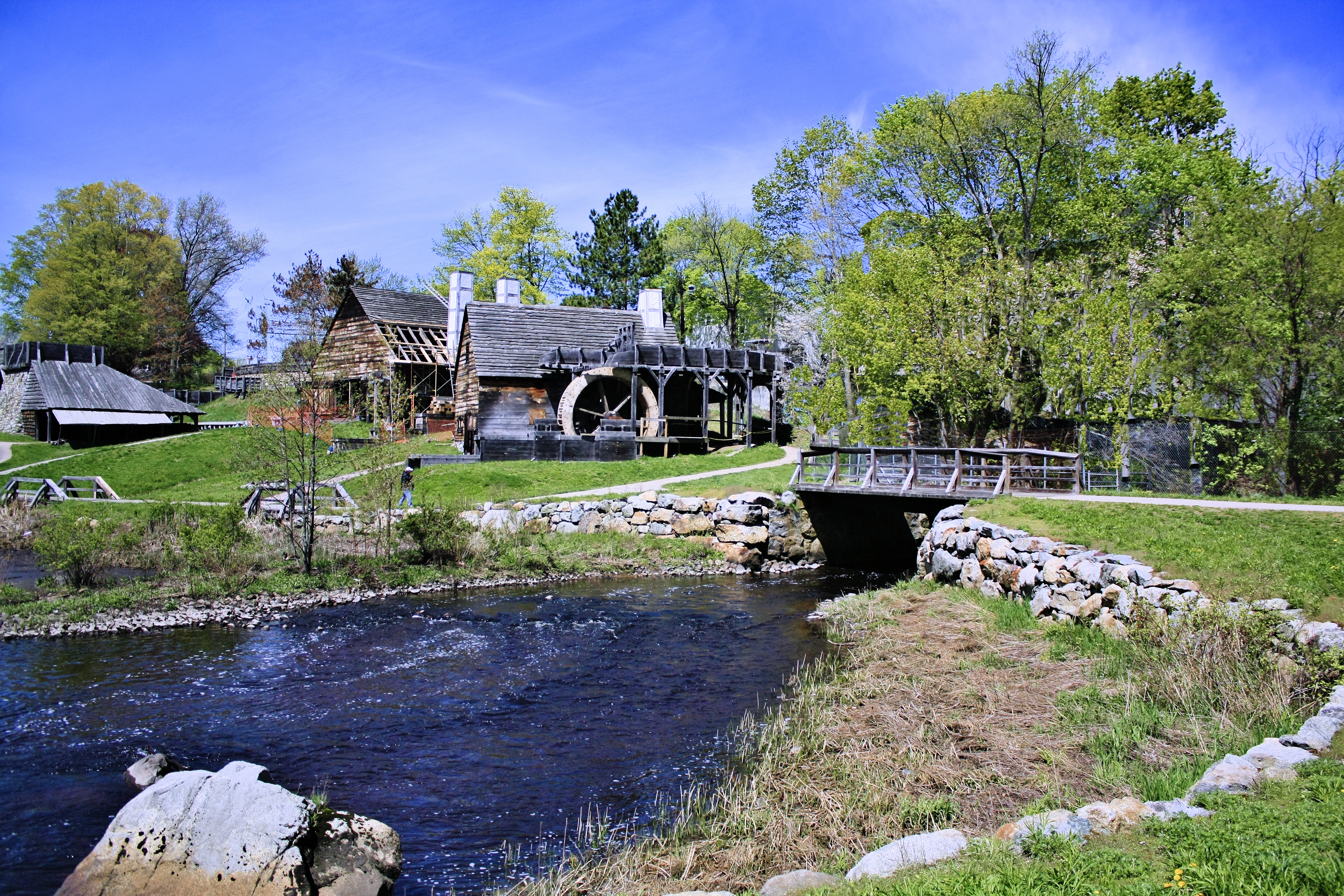 Historic mill complex in the background with a water inlet in the foreground.