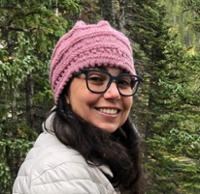 Smiling face of woman with dark hair.