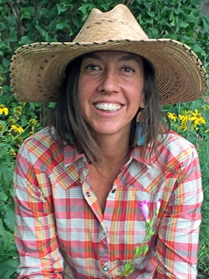Megan Swan Smiling woman in straw hat.