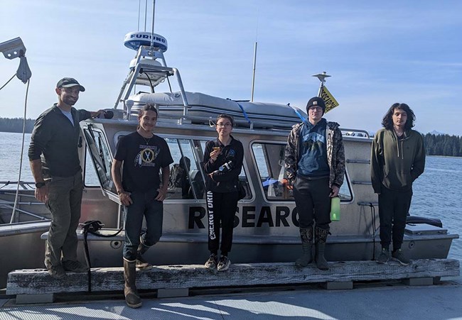 Young men stand by the park research vessel.