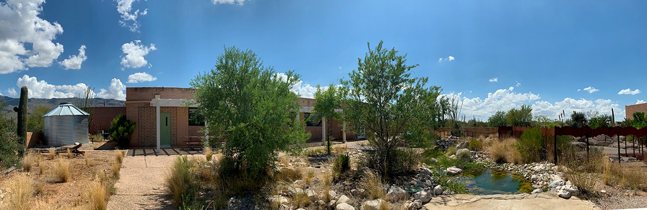 DRLC building Silver water tank, building, trees, and water feature