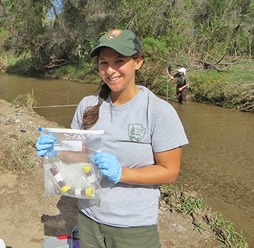 Water quality samples with streamflow monitoring in background