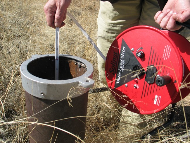 measuring water elevation Groundwater well with measuring tape for water elevation