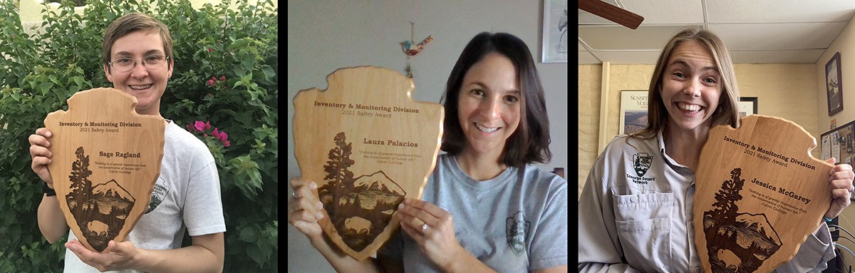 Three women hold arrowhead-shaped awards