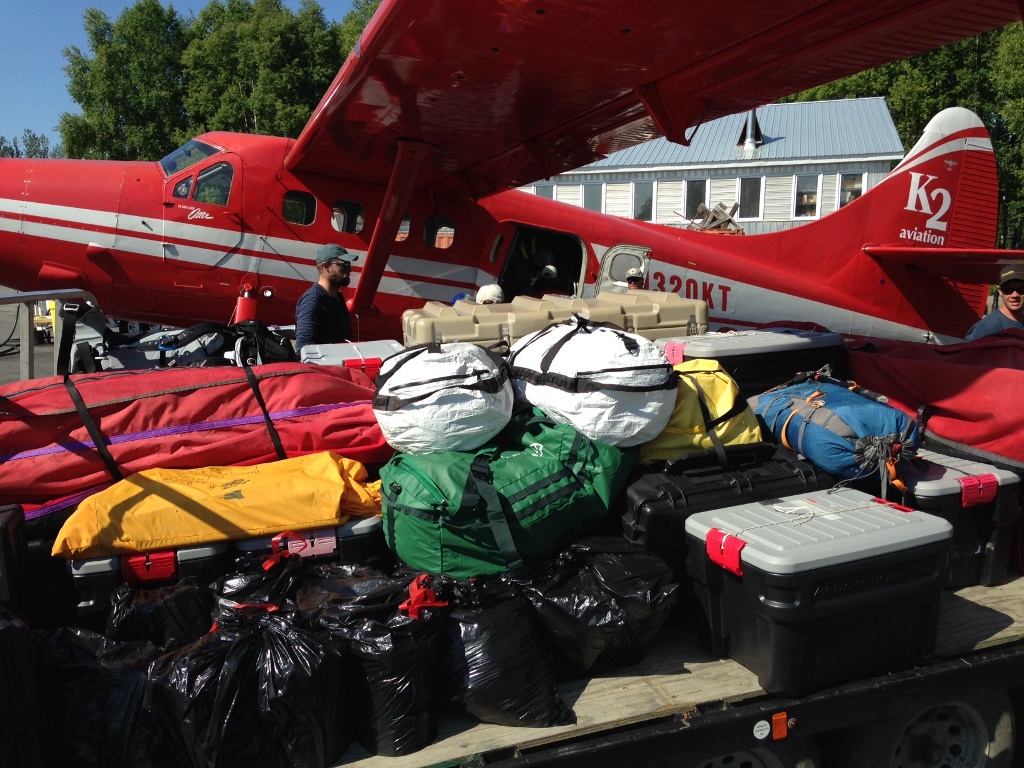 A trailer full of gear gets unloaded from an airplane