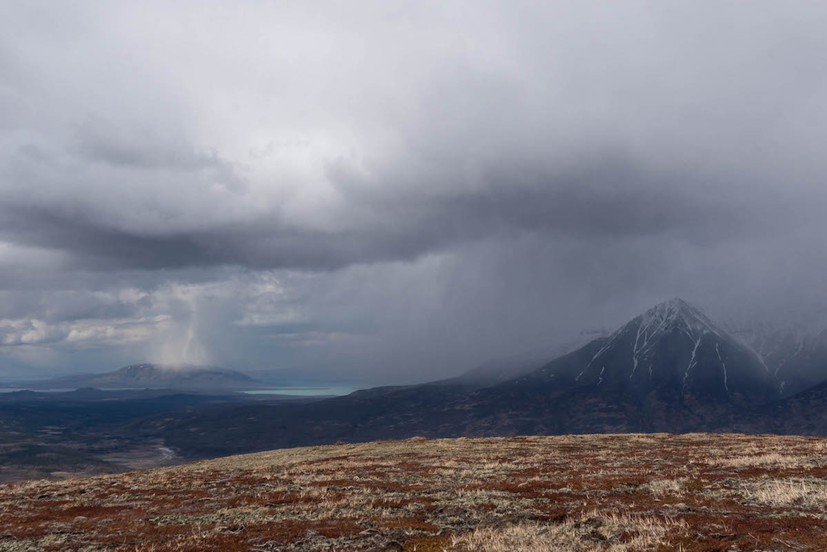 Storms roll in over a lake and mountains