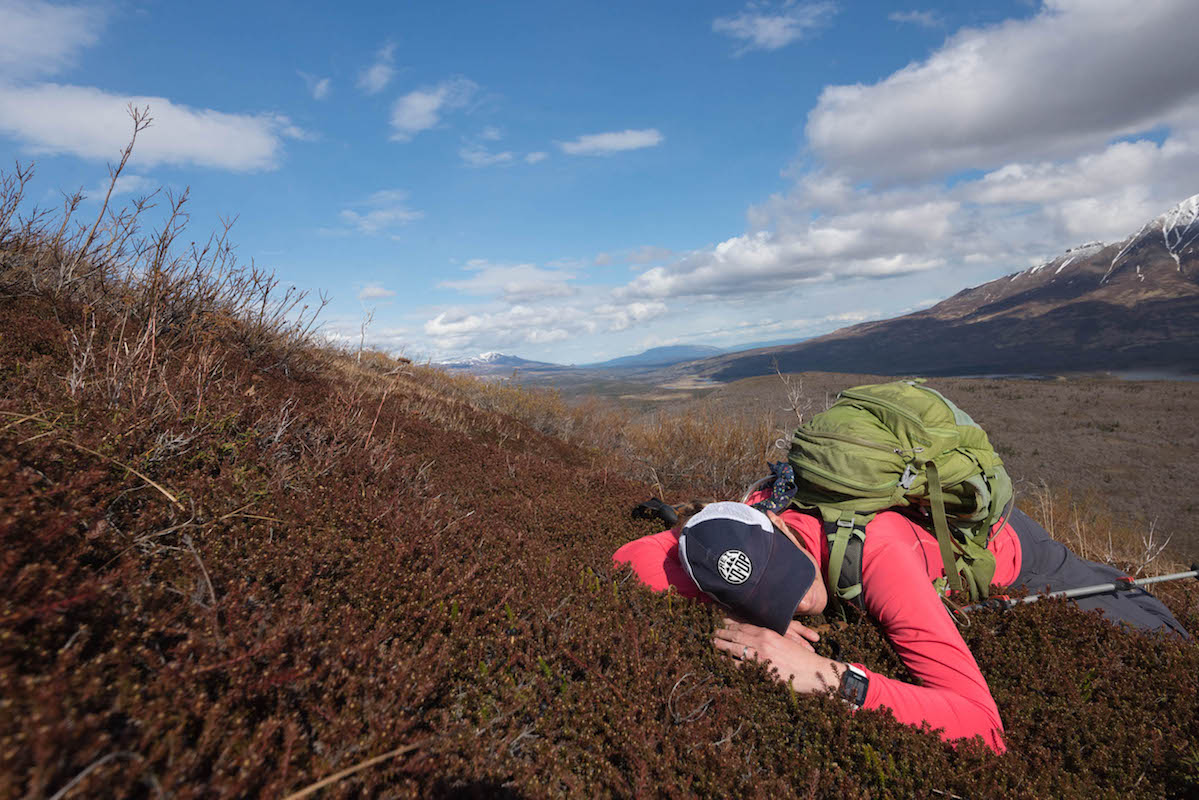 A woman lays her head in the soft tundra