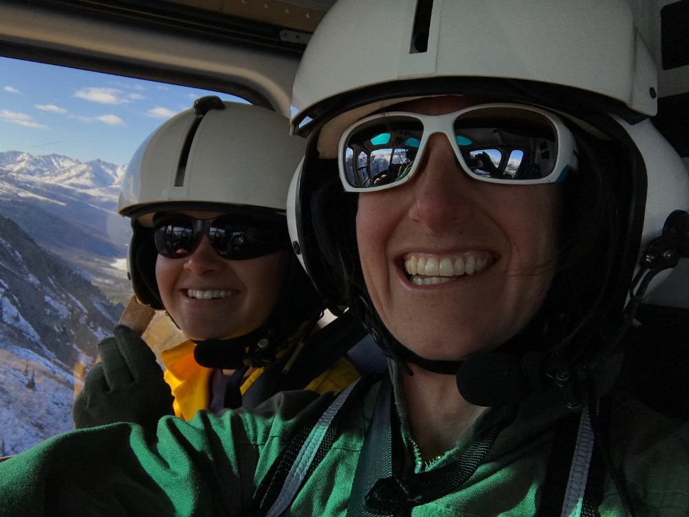 Scenic route home Two women fly through mountainous terrain in a helicopter