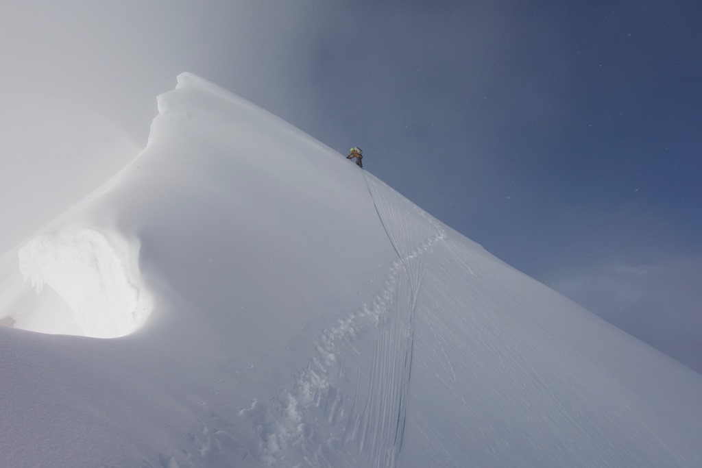 A roped climber nears the tippy top of Mount Frances