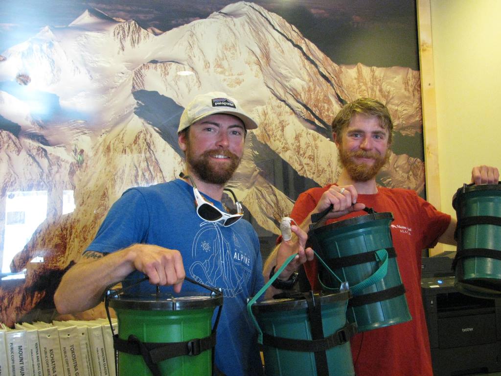 First two climbers of the season succeed with a full pack-out of waste Two climbers holding Clean Mountain Cans