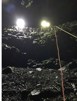 Searchers' spotlights peering down from above Searchers' spotlights peering down a cliff and wall from above