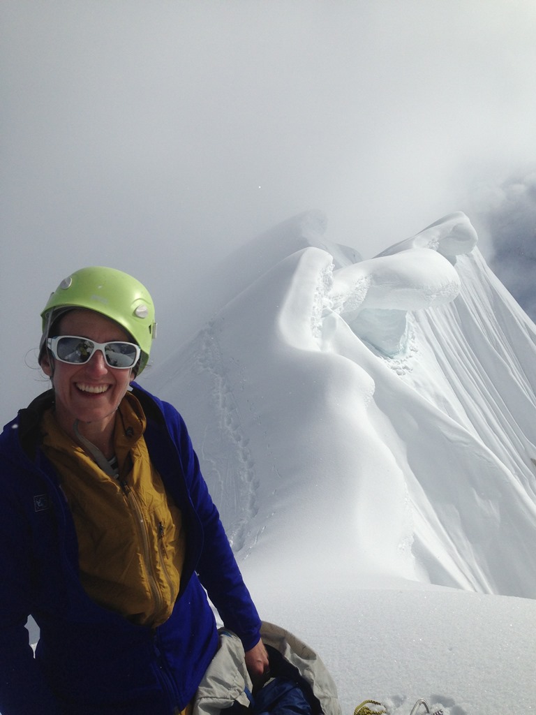 Melis on top A smiling climber with a dramatic cornice ridge in the backdrop