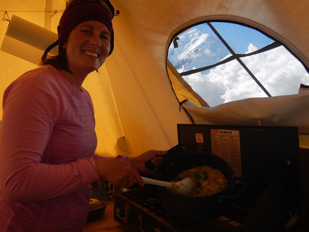 A ranger prepares a meal on a camp cookstove