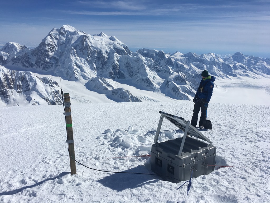 Looking back at Mount Hunter from the radio repeater site atop Mount Crosson A ranger sets up radio repeater equipment