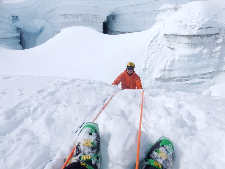 Crevasse rescue training A climber smiles as he climbs out of a crevasse
