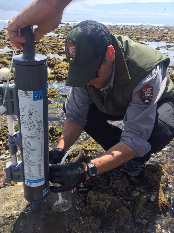 Ranger deploying instrument to monitor ocean acidification
