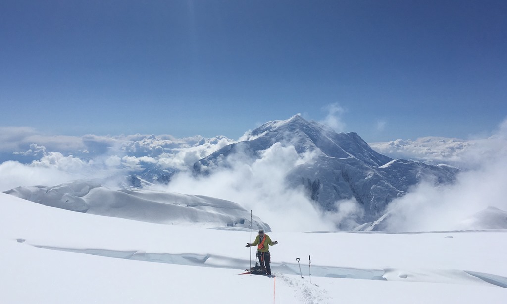 What's going on here? A confused climber stands in front of a crevasse, Mount Foraker in the backdrop
