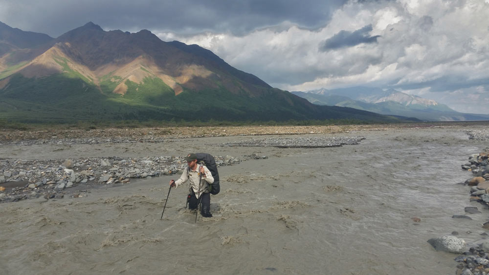 river crossing a man wading through thigh-deep water