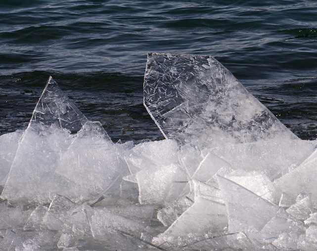 Clear, thin sheets of ice jumbled along the shore, a few standing straight up in the air
