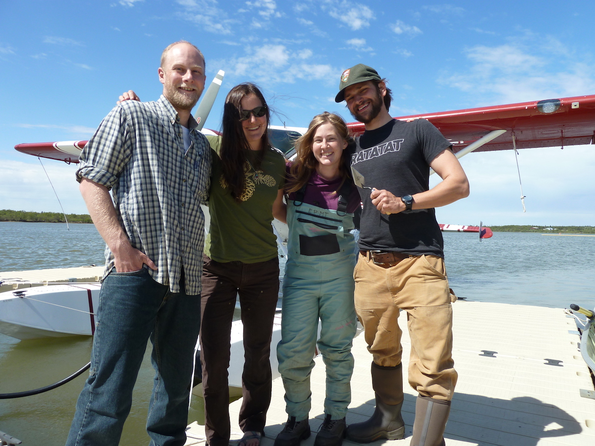 Archeologists pose for a photo in front of a float plane