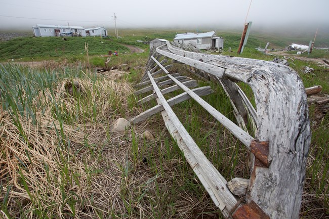 Wales village with umiak in the foreground.