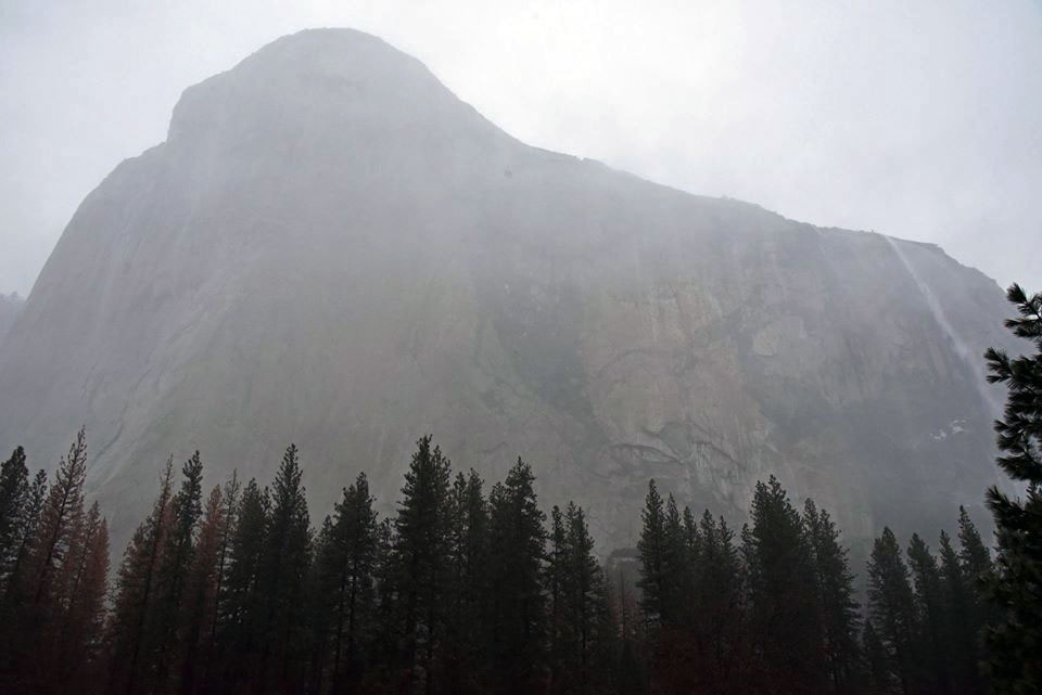 Granite monolith with a waterfall seen through rain