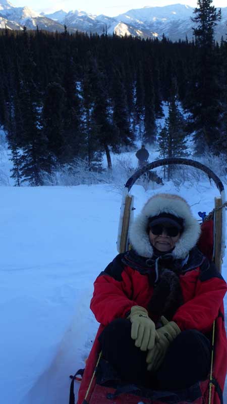 a woman in winter gear sitting in a sled