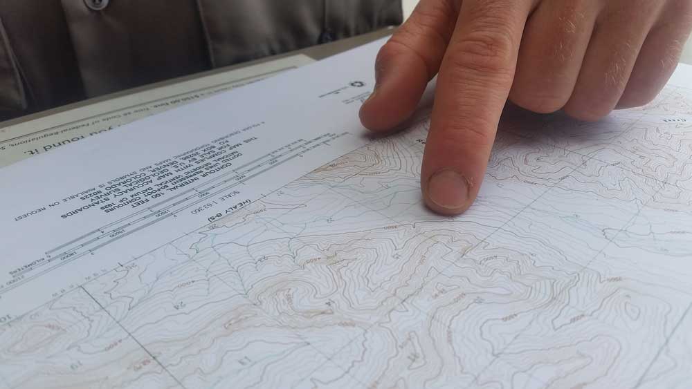 closure of a person pointing on a topographic map