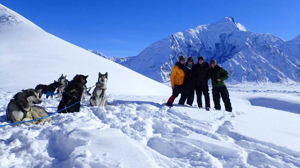 rangers and sled dogs in a snowy mountain pass
