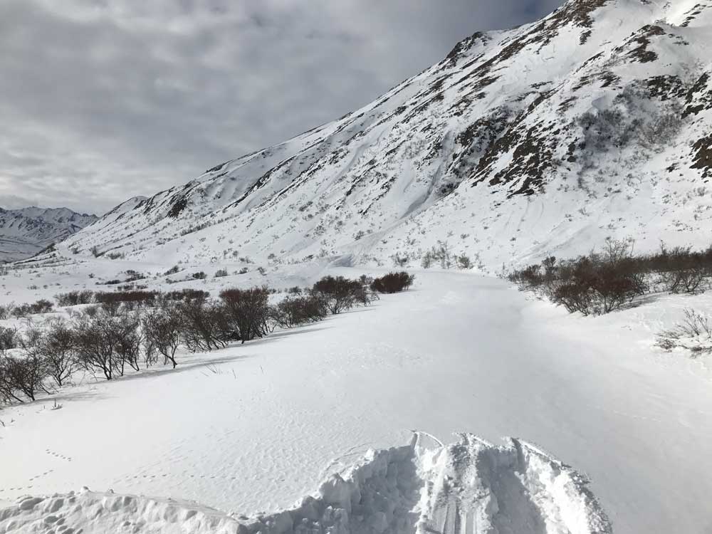 distant snow slide a snow covered mountain with a snow-covered road along its flank