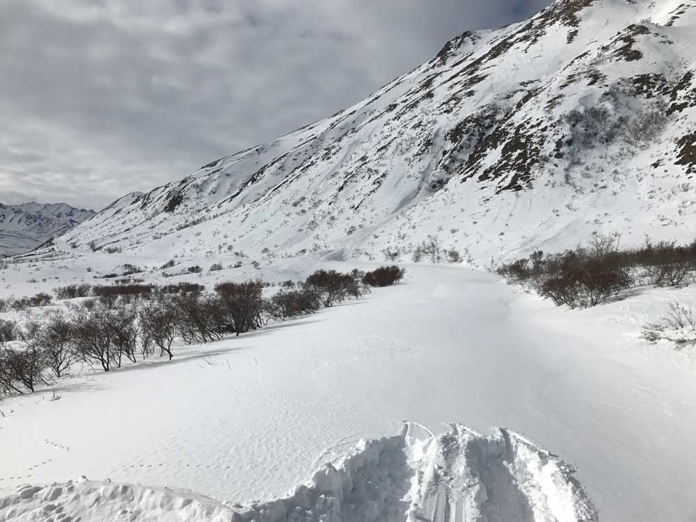 a snow covered mountain with a snow-covered road along its flank