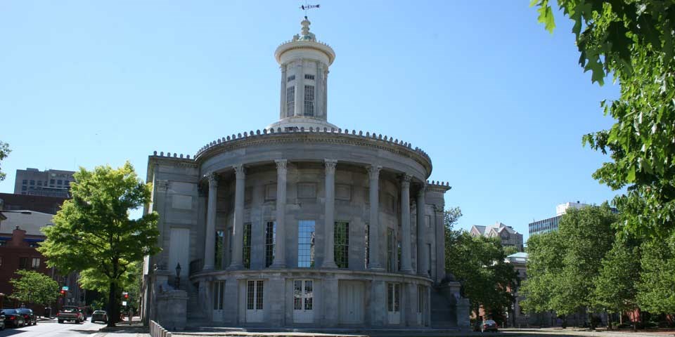 Color photo showing rounded east facade of marble building with many columns. Color photo showing rounded east facade of marble building with many columns.