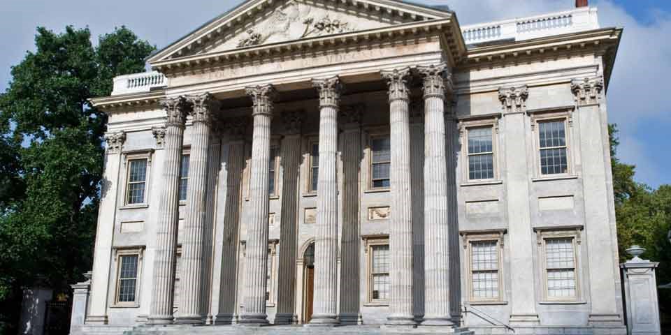 Color photo showing two-story marble building with multiple columns supporting a triangular pediment.