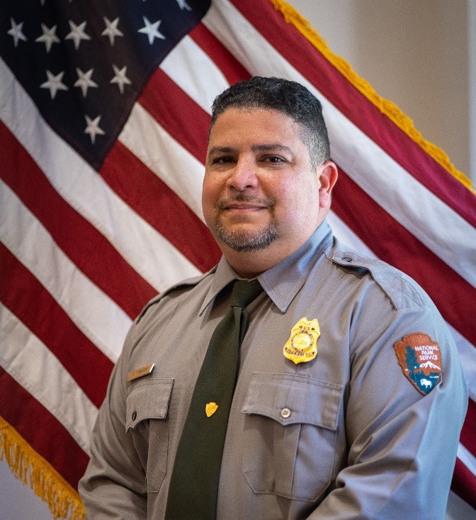 Adrian Fernandez in uniform Adrian Fernandez in NPS uniform with US Flag in background