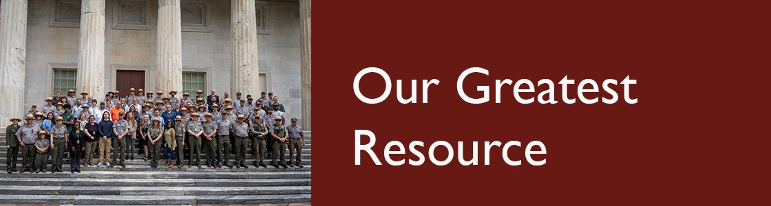 National park staff standing on an outdoor marble staircase with large marble pillars in the background.