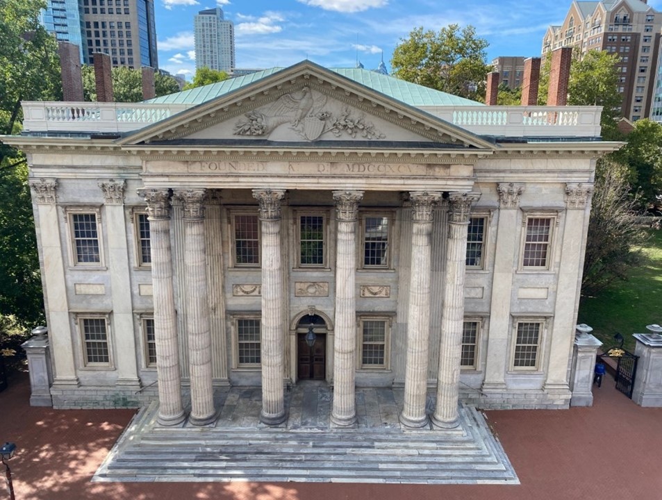 A building with marble facade with six columns and steps leading to front door. A large carved eagle is on the the building's triangular pediment above the columns, the display of an enormous eagle "seals the deal" as a representation of America's power.