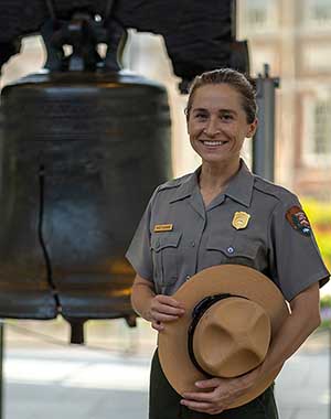 Amnesty Kochanowski A person wearing National Park Service uniform in front of a large bell