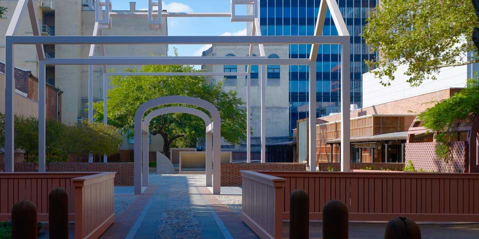 Color photo looking into the courtyard at Franklin Court, an outdoor area with a steel white frame shaped like a house.