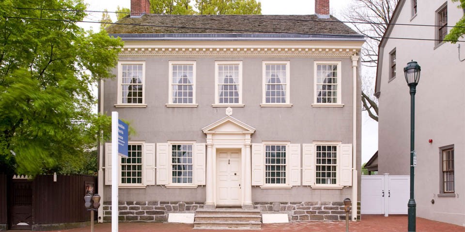 Color photo showing the exterior of the home, a two story structure.