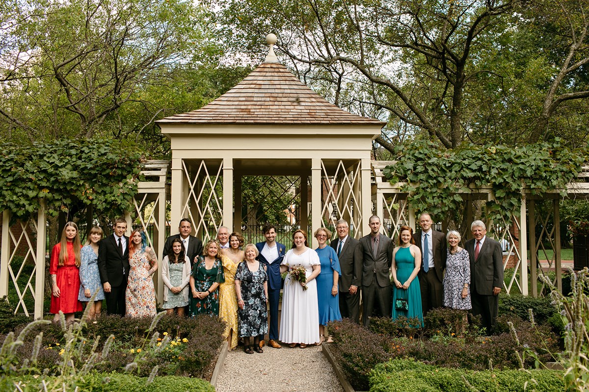 Wedding party posing for photos in garden with gazebo