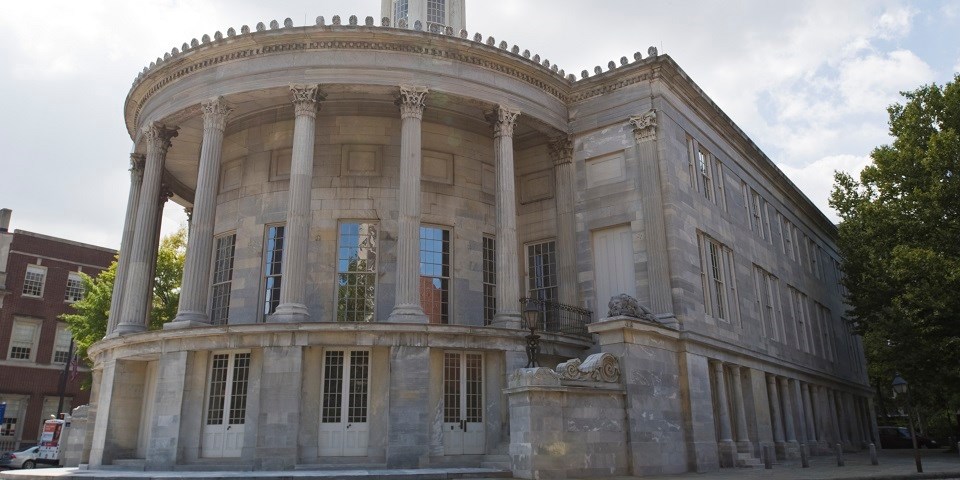 Color photo showing rounded facade of marble building with multiple columns.