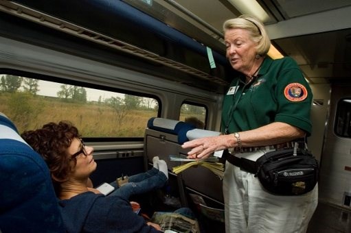 Rails & Trails volunteer talking with Amtrak passengers on the train