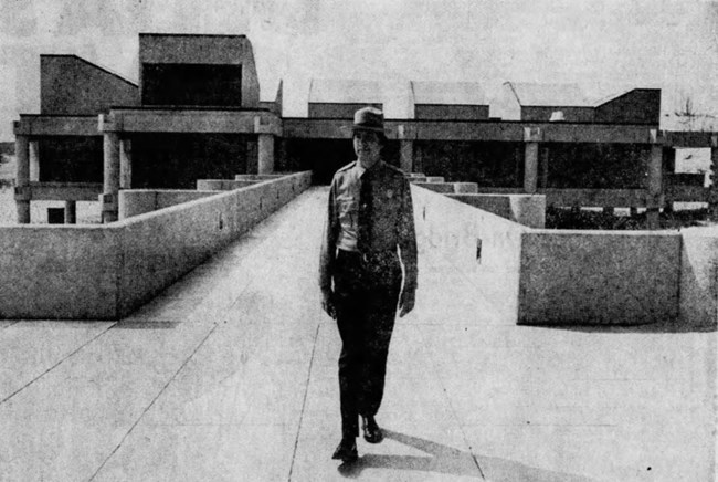 Park ranger at bath house Black and white photograph of an NPS ranger standing in front of the newly constructed West Beach Bath House.