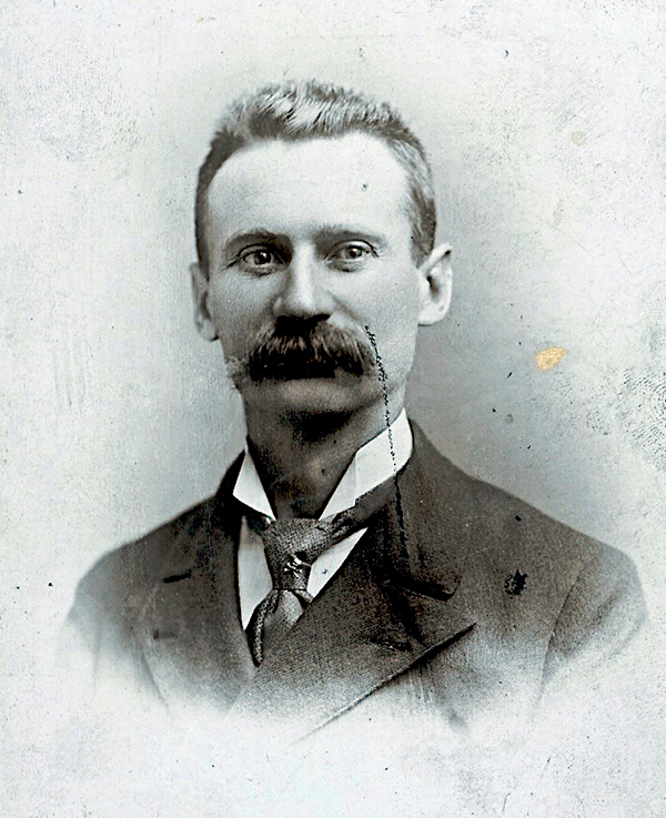 Black and white photographic portrait of Jens Jensen sporting a large dark mustache and a suit and tie.
