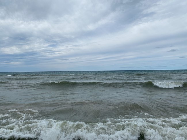 View of Lake Michigan from the shore on a gray day with waves rolling in