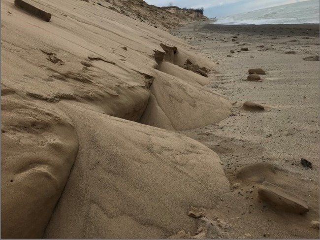Piles of sand along the northern edge of a dune on the shore of Lake Michigan