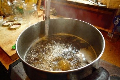 Golden sap or syrup boiling in a pan on a stove.