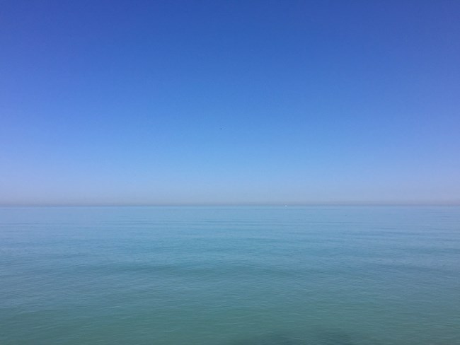 The blue of the sky merges with the blue of the lake