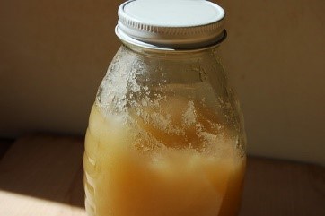 A glass jar filled with light tan maple sugar